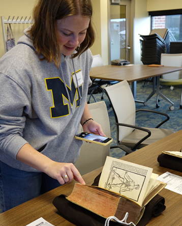 Abigail Kramer paging through old anatomy books in the Special Collections Library